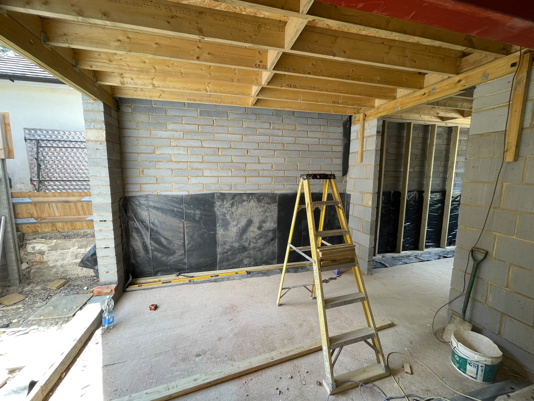 Timber roof framing and brickwork during rear extension construction