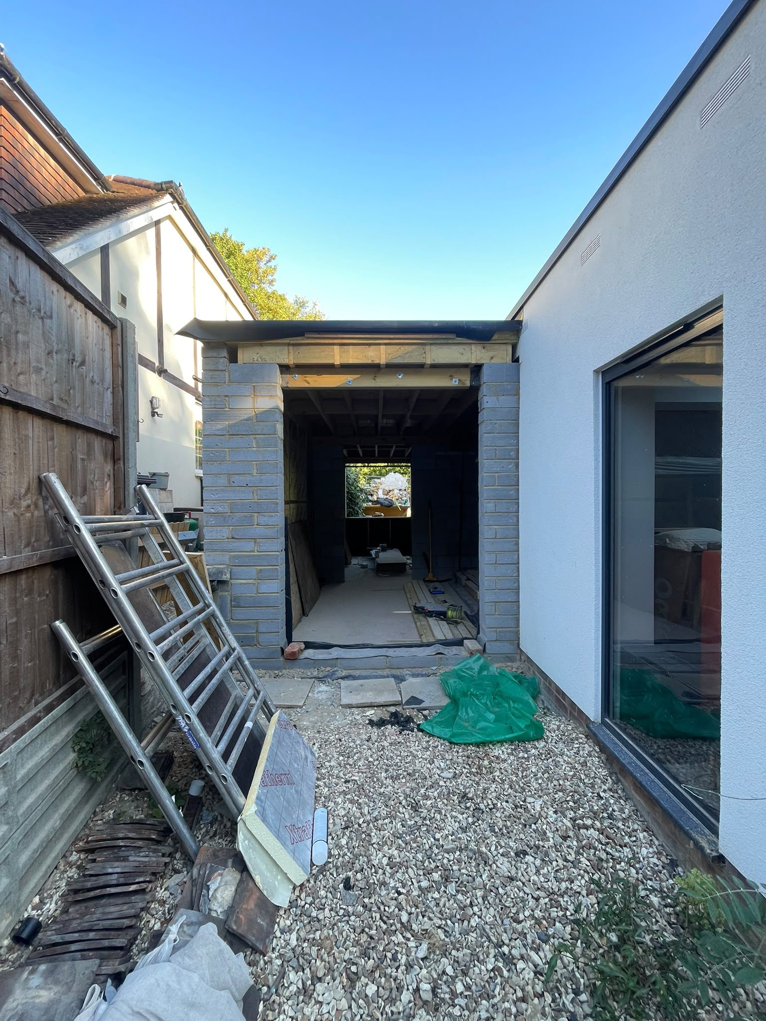 Rear property extension construction with brickwork, timber framing and roofing work