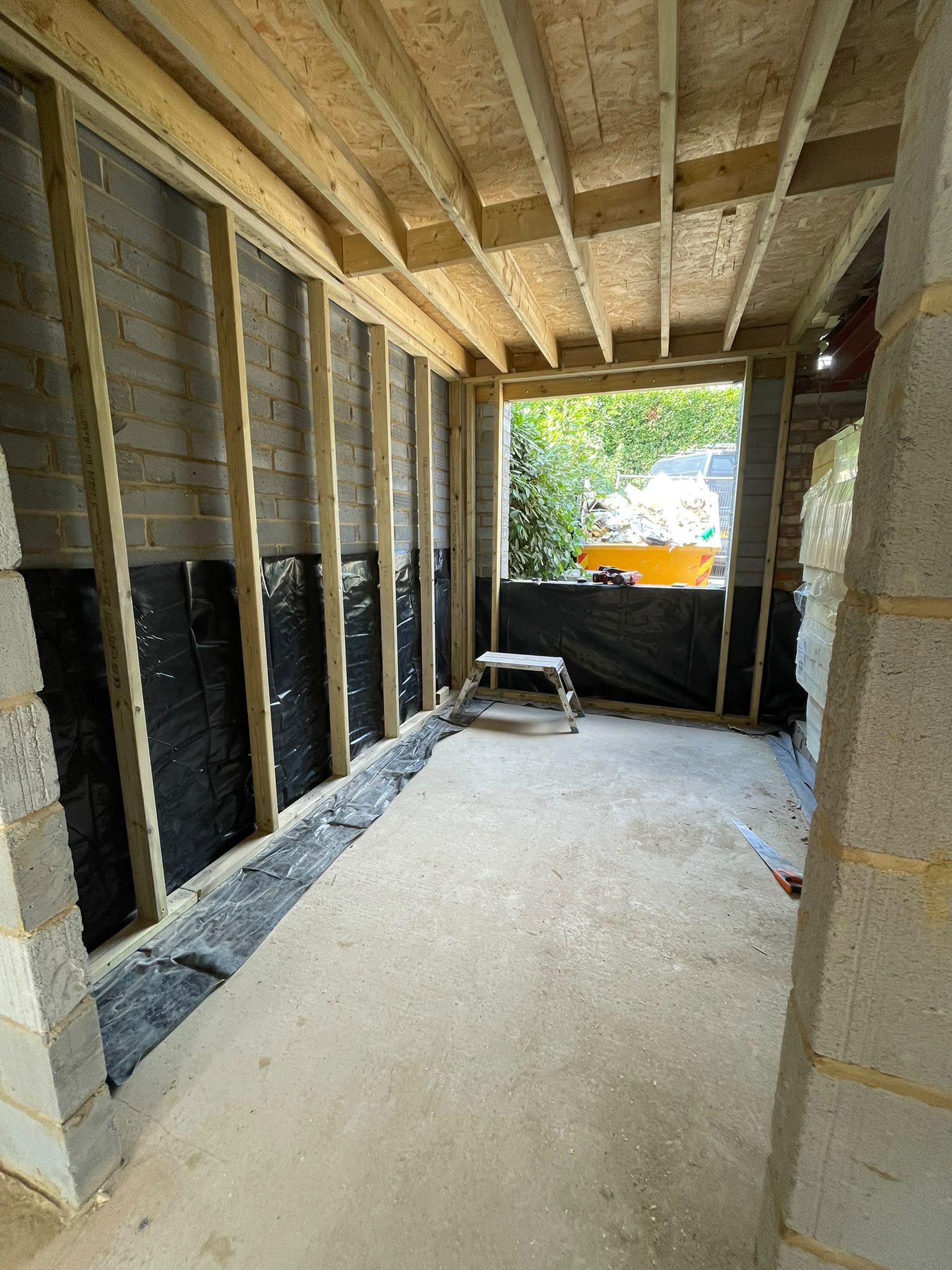 Timber framed extension under construction with insulated walls and roof structure